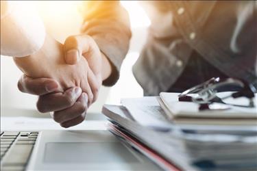 two people shaking hands over an optometry practice acquisition