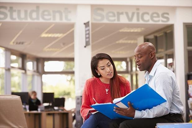 College student sitting in career center getting advice on their resume