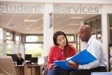 College student sitting in career center getting advice on their resume