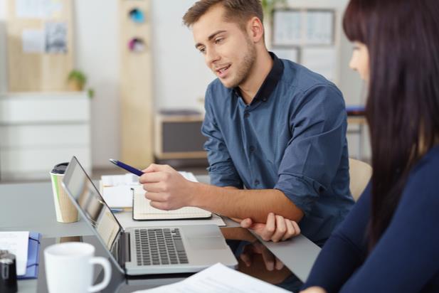 employee collaborating with a mentor on a laptop