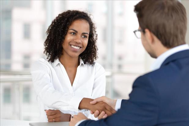 Candidate shaking hands with hiring manager after successful salary negotiation 