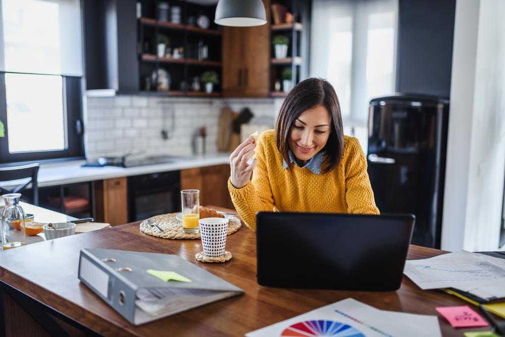 person working on their laptop in their kitchen