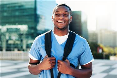 smiling nurse outside wearing his backpack