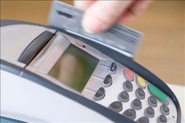 Credit card being swiped through a processing machine