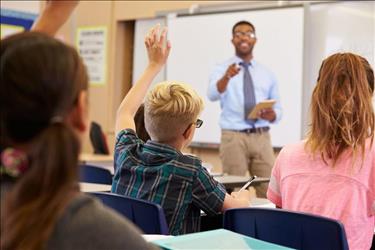 elementary school teacher in front of classroom