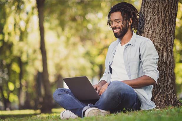 happy person working on his laptop outside