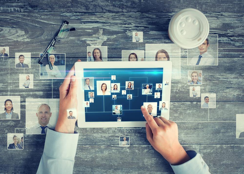 professional networking concept image with person on tablet and photos of people in their network