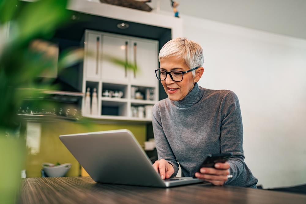 woman working on her computer in her kitchen