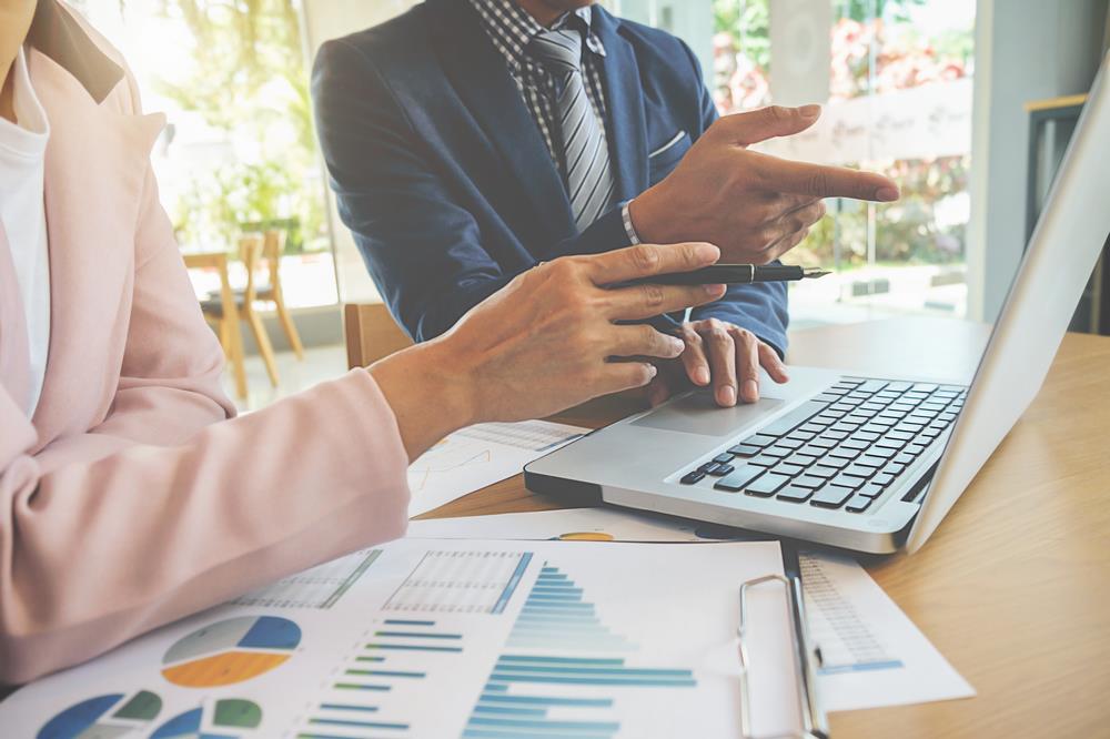 two accountants reviewing financial data together on a laptop