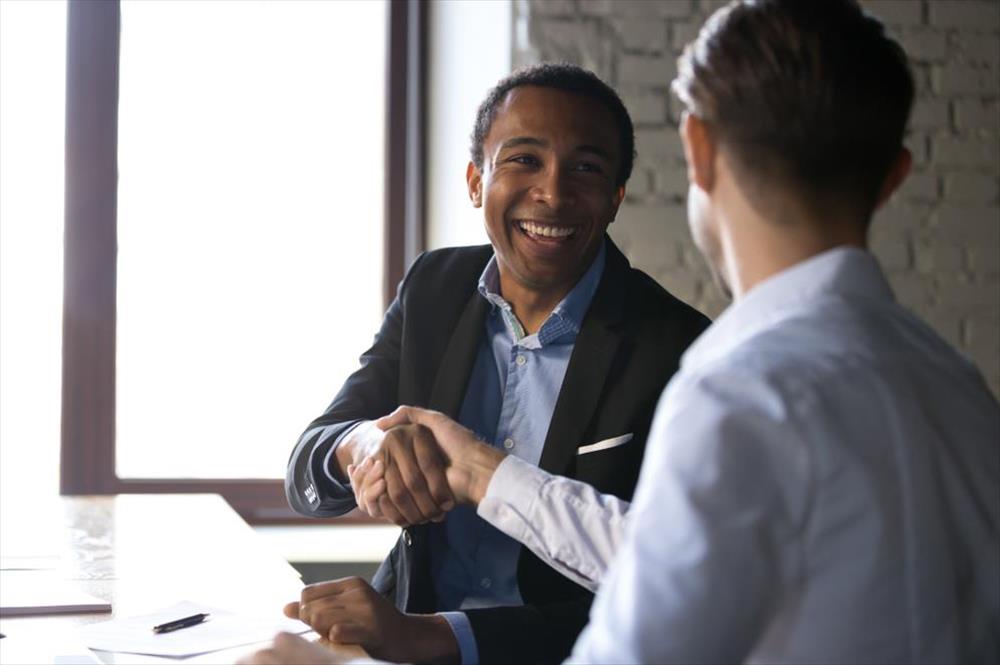 Man shaking hands with employer after negotiating job offer