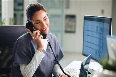 smiling medical assistant answering the phone