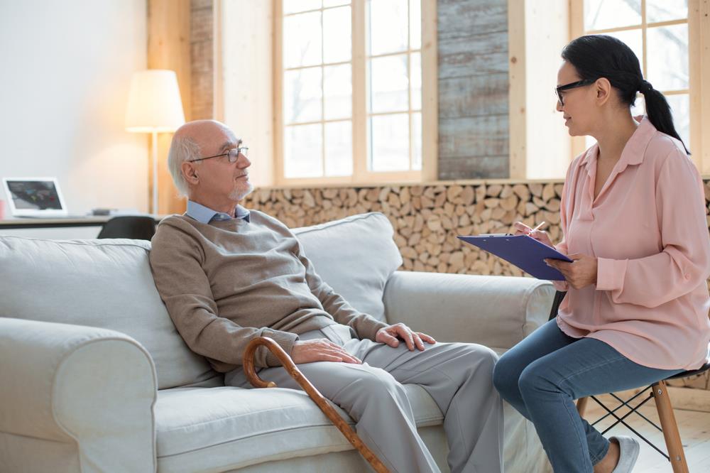 gerontology social worker meeting with a client in his home