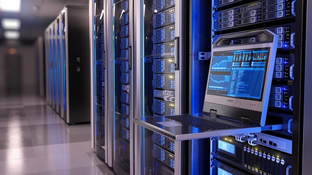 Empty server room with open laptop in the foreground