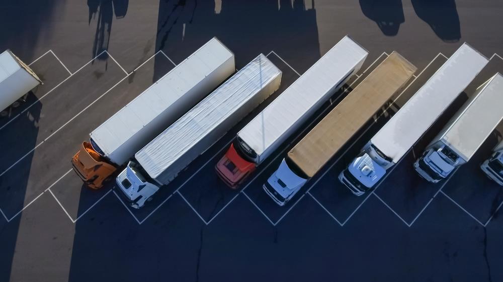 Birds-eye view of a group of semi trucks in a parking lot.