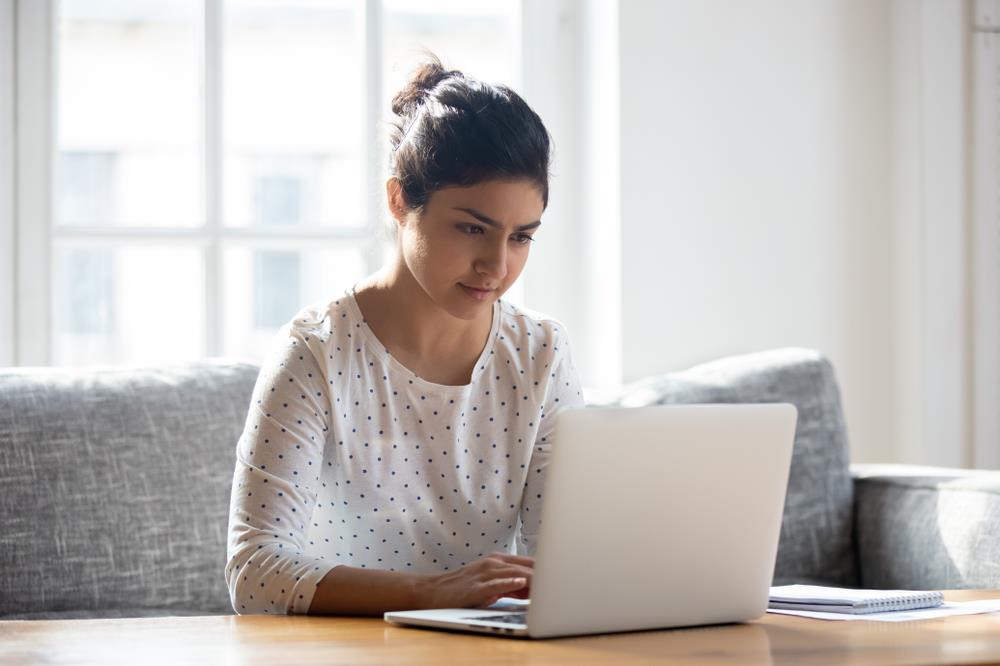 woman composing email on laptop at home