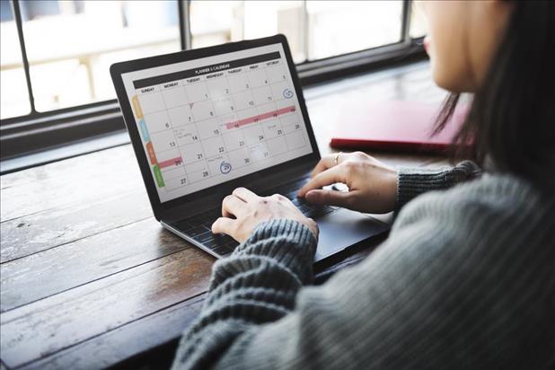 Job seeker reviewing schedule on laptop