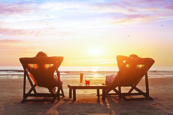 two people lounging on the beach