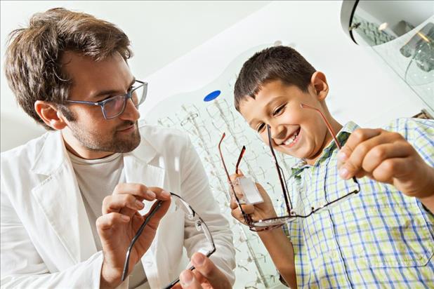 volunteer optometrist helping a child pick out glasses