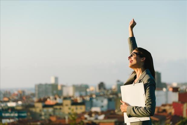 Job seeker celebrating success with city as backdrop