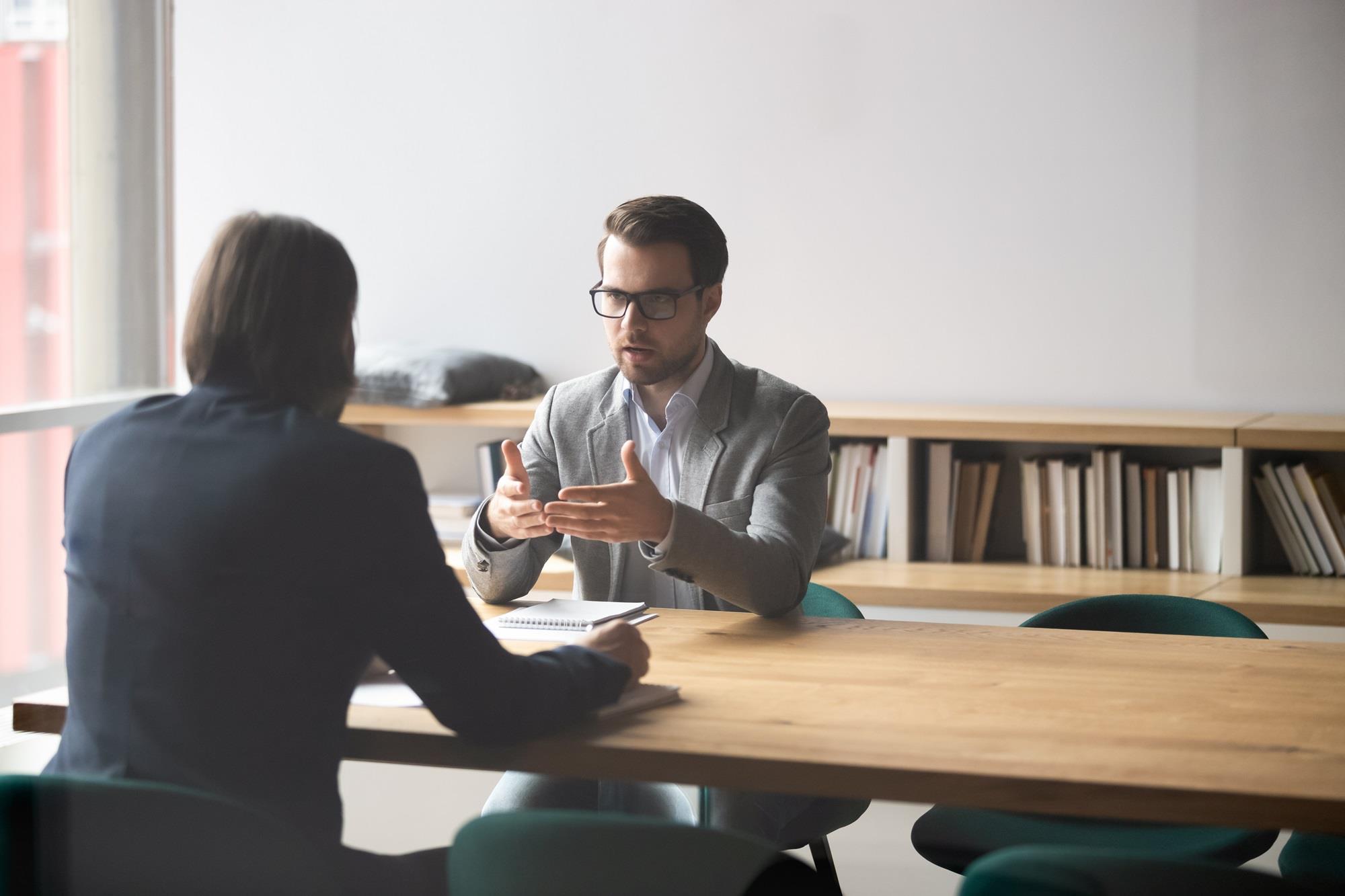 two employees having a serious conversation in a boardroom