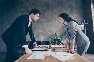 two conflicting employees on either side of a table