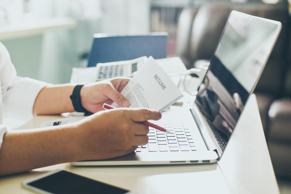 job seeker editing resume at laptop