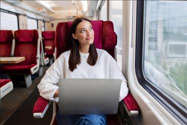 woman using her laptop while riding a train