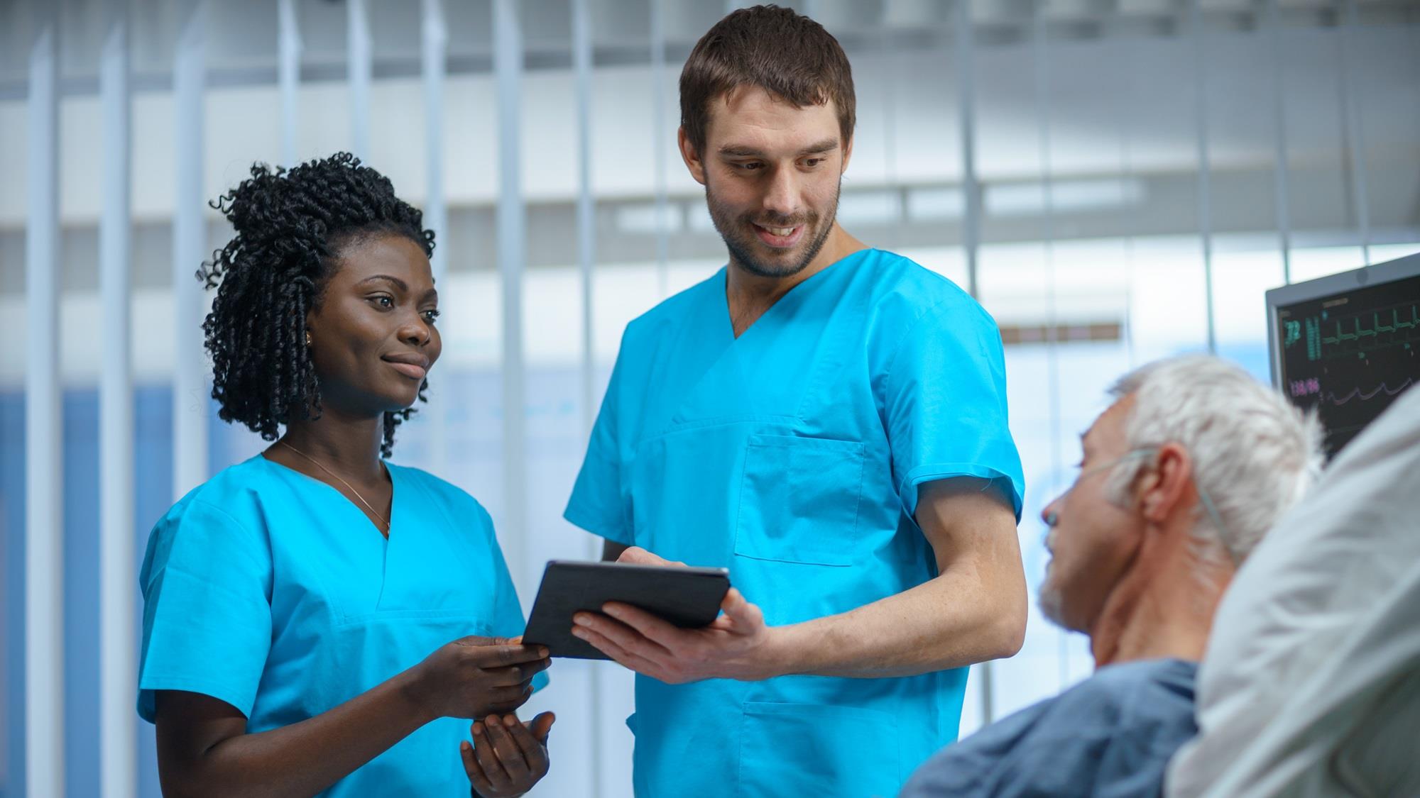 two hospital workers providing bedside care