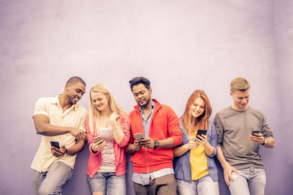 group of young professionals looking at smartphones