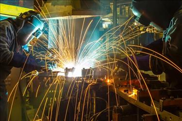 Two welders in steel fabrication facility