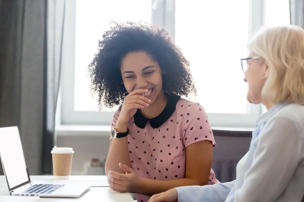 Intern laughing with colleague in meeting