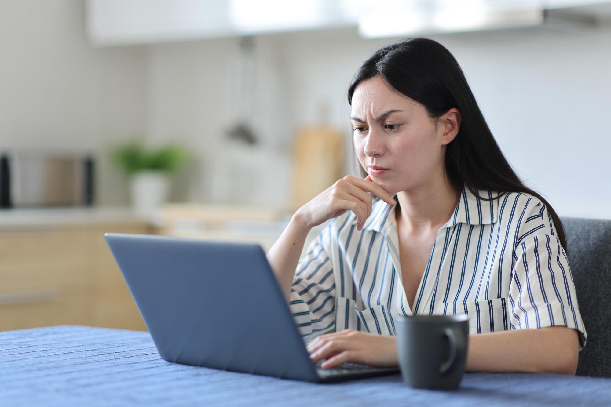 woman working on her laptop with a concerned look on her face