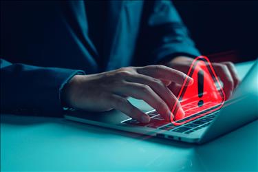 man typing with a red warning graphic overlaid on the keyboard