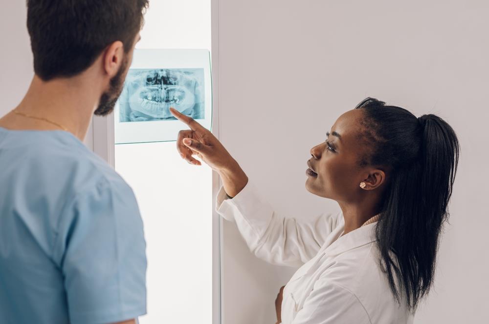 two dental team members looking at an x-ray