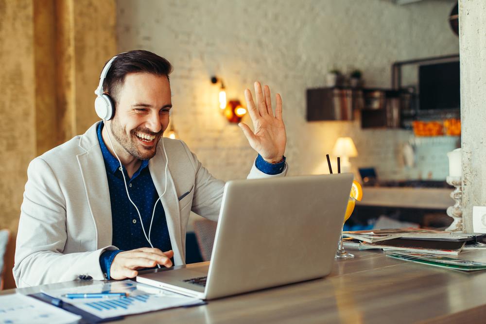 Hiring manager on a video call enthusiastically rehiring his laid-off employee