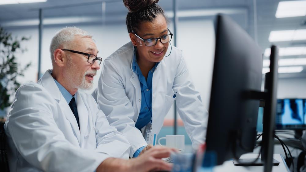 two healthcare professionals looking at a computer together