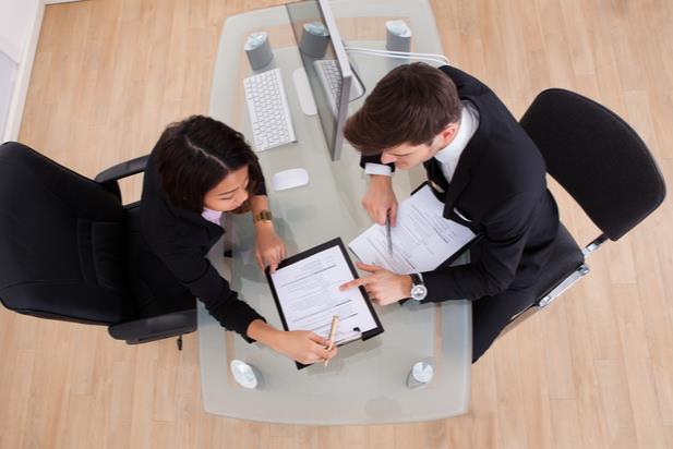 employees working at a desk looking at a document