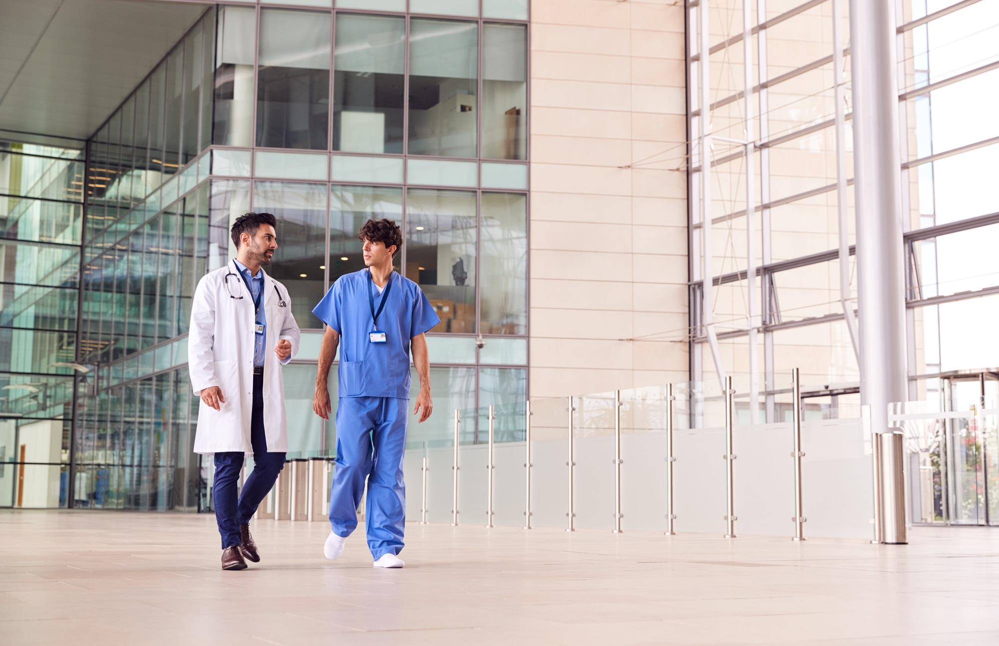 two medical team members talking while walking outside