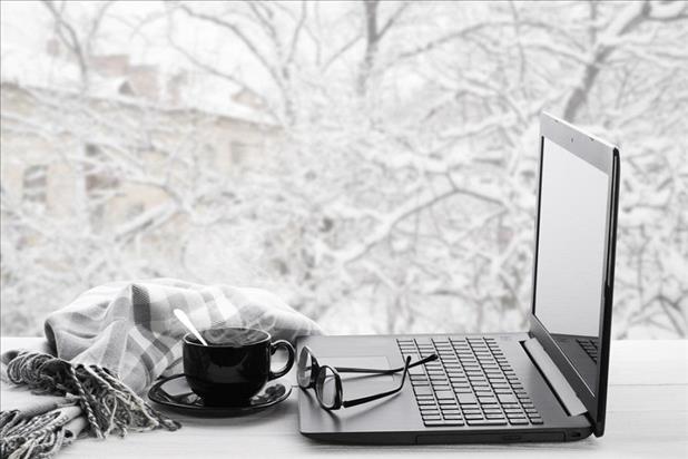 computer on a desk with a snowy scene outside