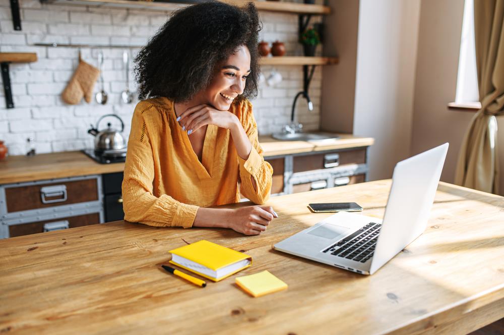 happy employee working remotely from her kitchen