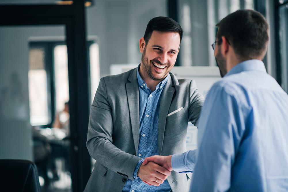 Men shaking hands in office