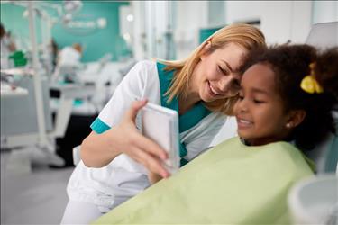 Dental assistant with young patient