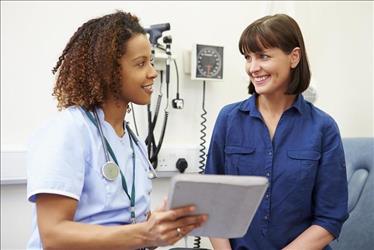 Nurse sitting with a patient, reviewing her chart