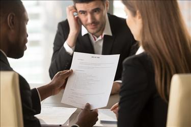 Candidate looking nervous while interviewers review his resume