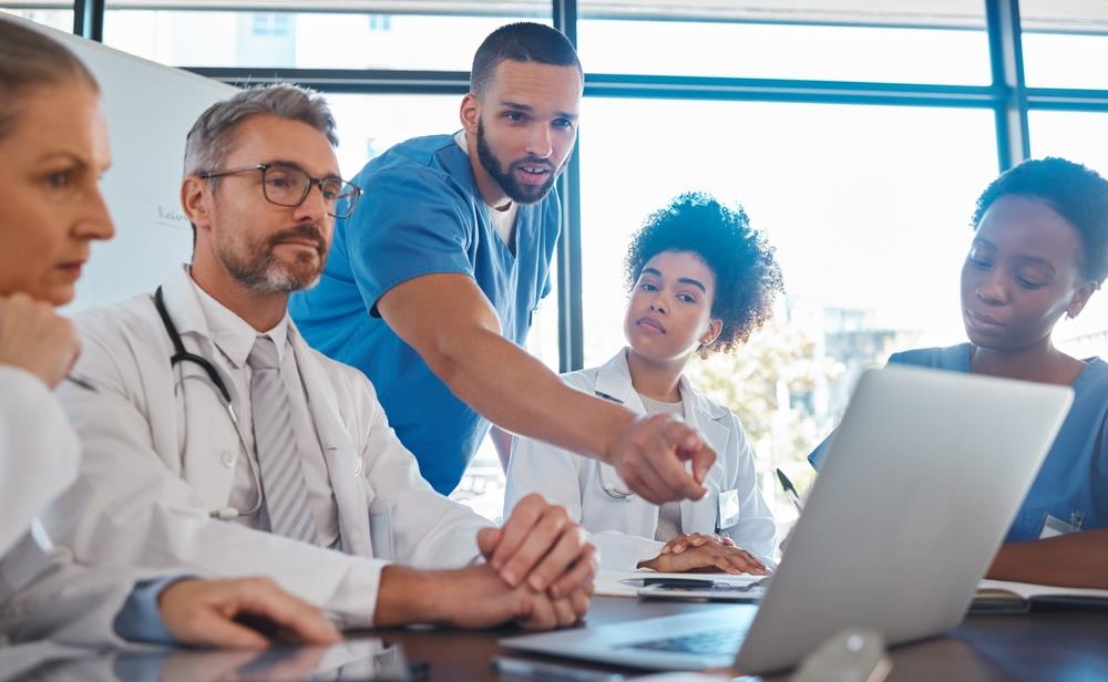 group of healthcare professionals looking at laptop