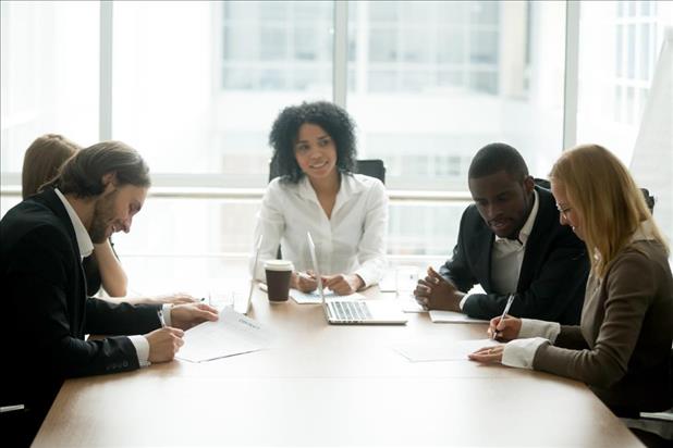 leader running a team meeting in her office's conference room