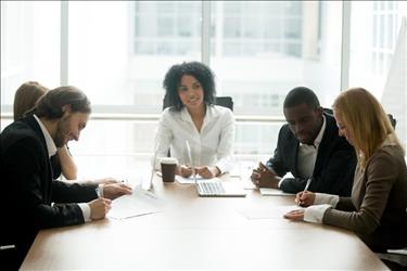 leader running a team meeting in her office's conference room