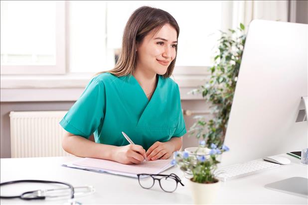 happy healthcare professional working on her computer