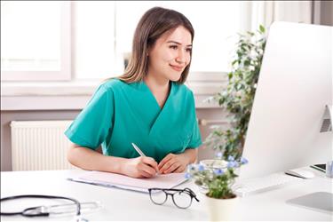 happy healthcare professional working on her computer