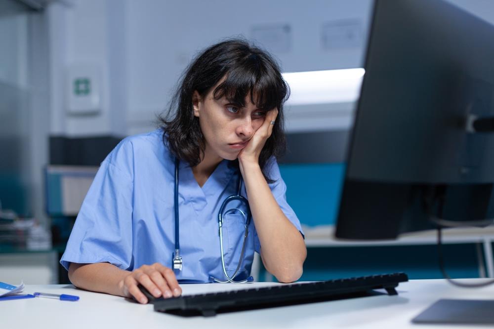 sad nurse at computer